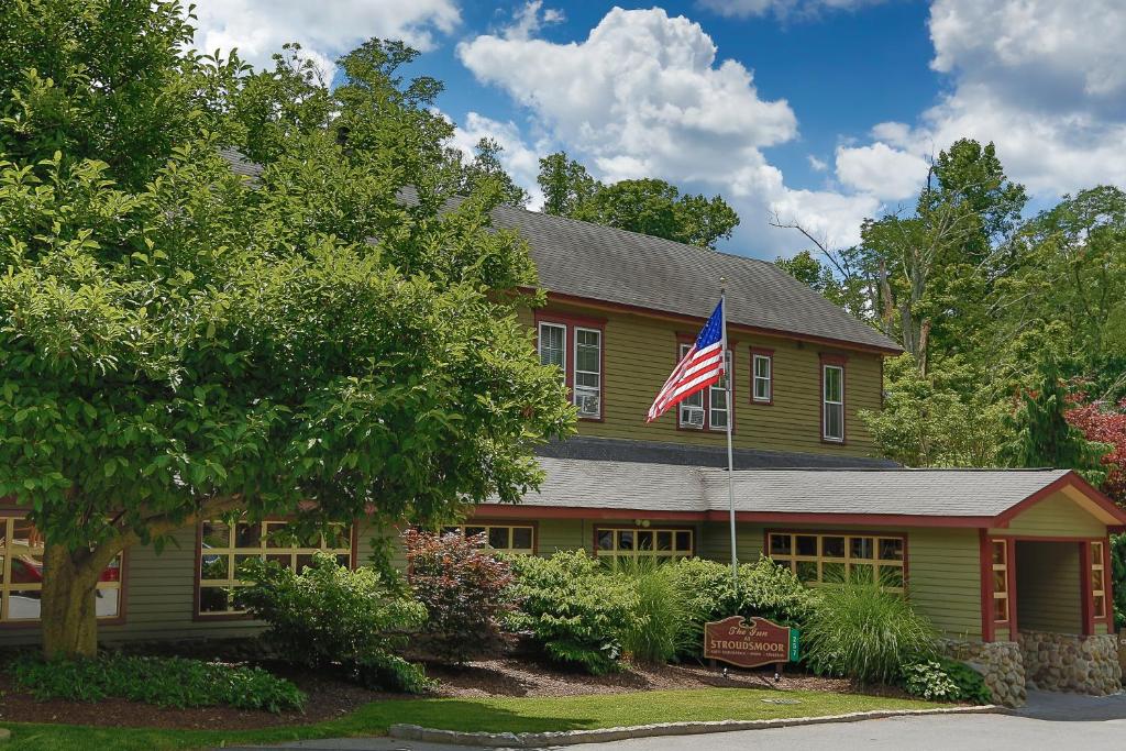 une maison arborant un drapeau américain devant elle dans l'établissement Stroudsmoor Country Inn, à Stroudsburg