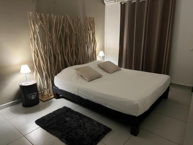 1 dormitorio con cama, lámpara y alfombra en BLACK CANE LODGE, en Saint-Claude