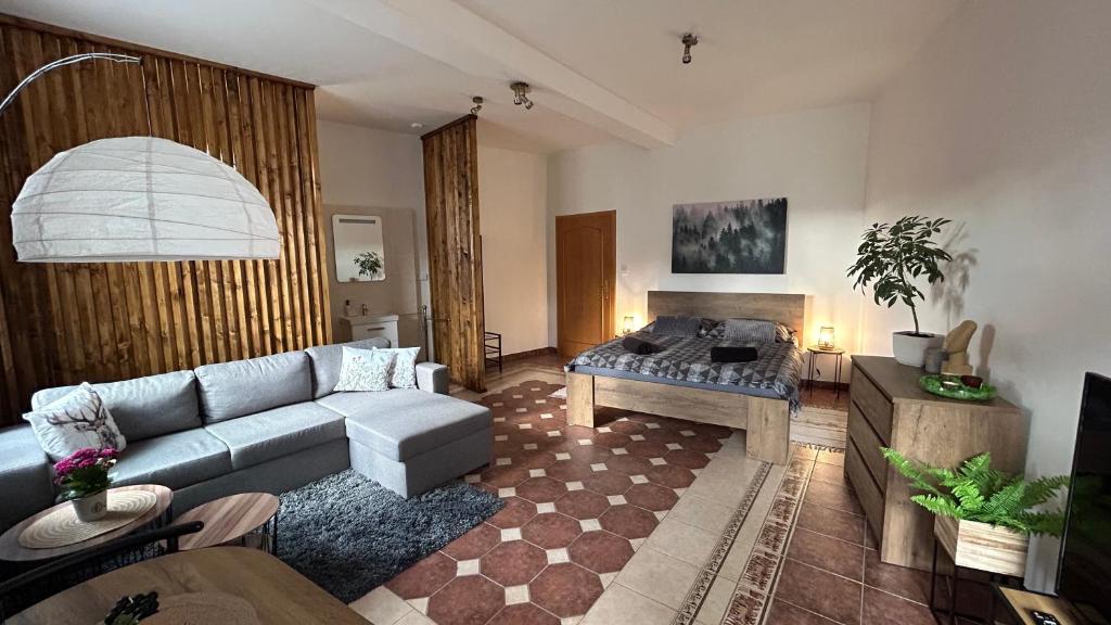 ein Wohnzimmer mit einem Sofa und einem Tisch in der Unterkunft Apartmán Smrk in Vrbno pod Pradědem