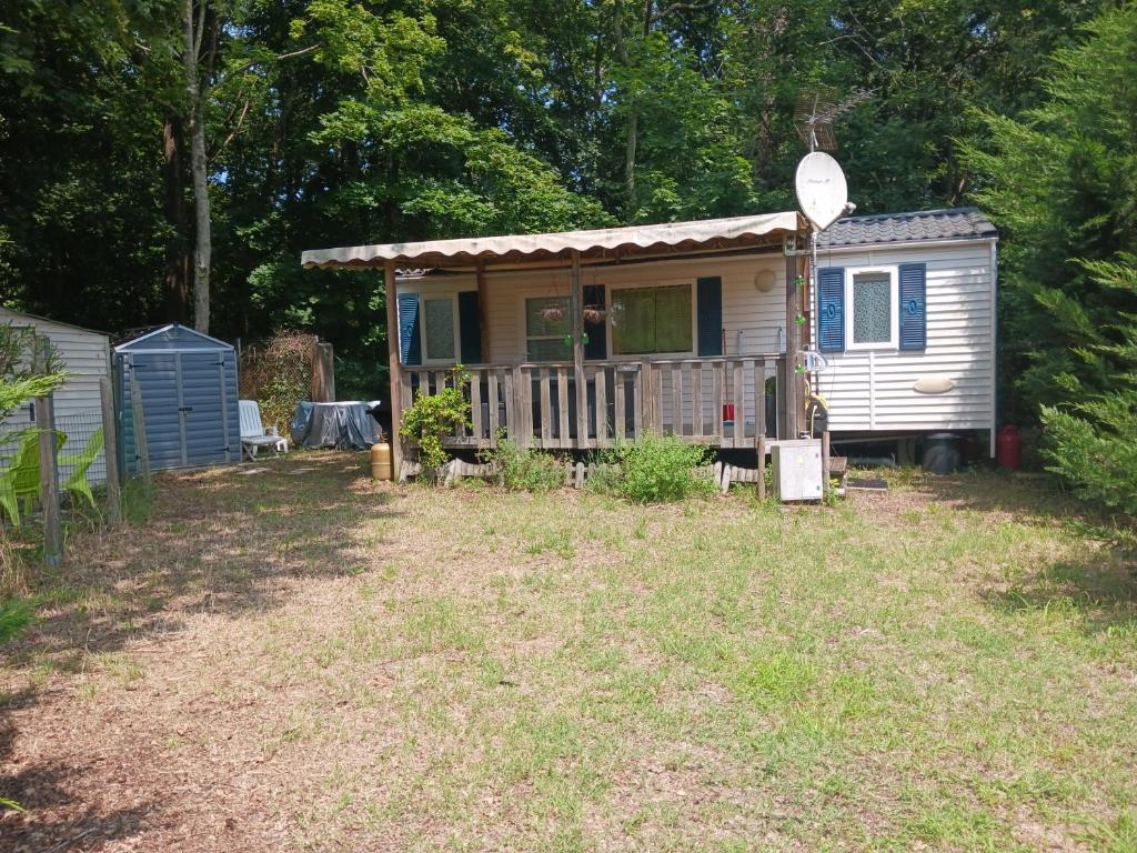 une petite maison dans une cour avec une terrasse couverte dans l'établissement MH 287 à LA TREMBLADE, à La Tremblade
