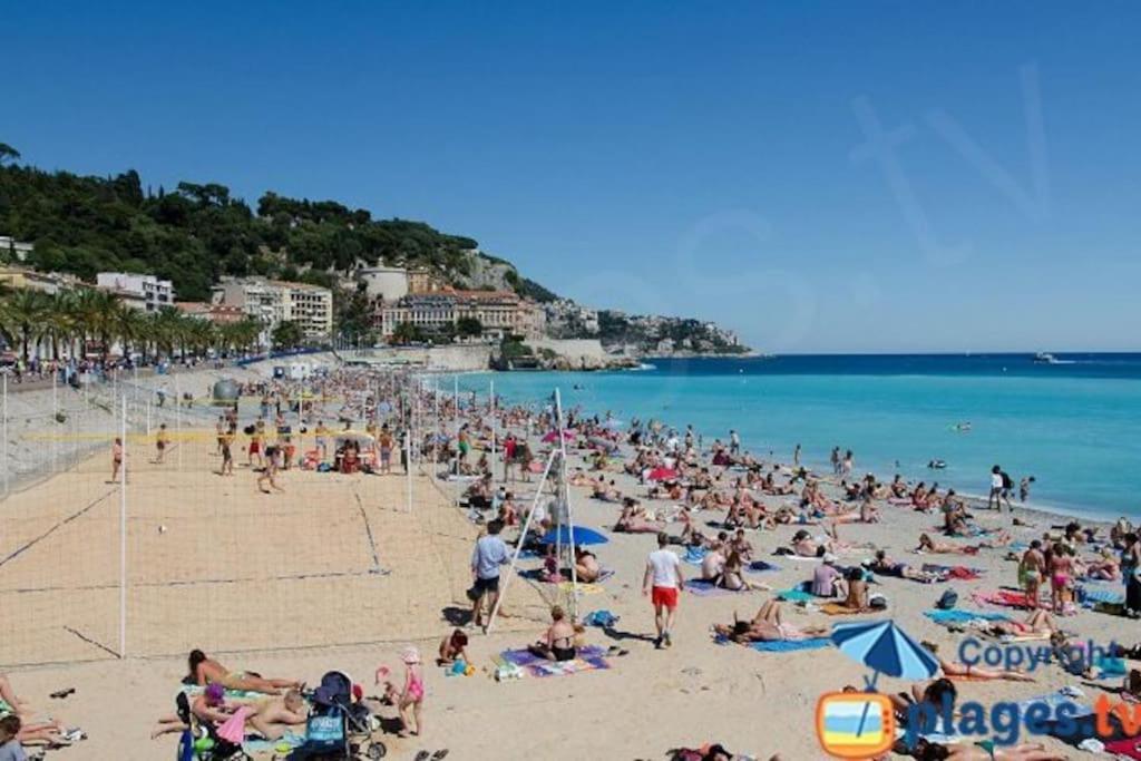 eine große Menschenmenge am Strand in der Unterkunft 3 Pièces proche mer et aéroport in Nizza