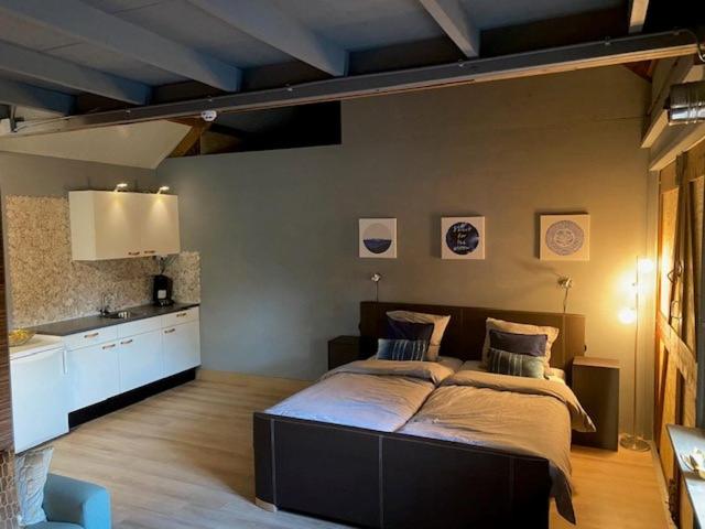 1 dormitorio con 1 cama grande y cocina en Shed 100, en Westerlee