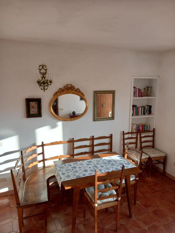 une salle à manger avec une table, des chaises et un miroir dans l'établissement Nora's House Elba Island, à Marciana