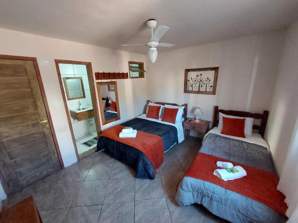 a hotel room with two beds and a mirror at Astral de Minas in Tiradentes