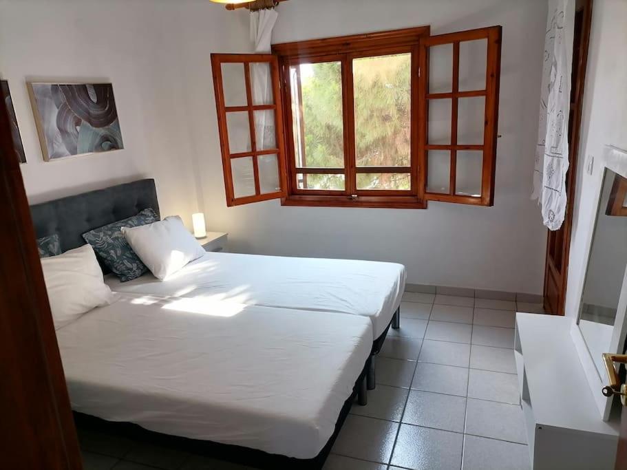 een slaapkamer met 2 bedden en een raam bij Pine & sea house in Nikiti