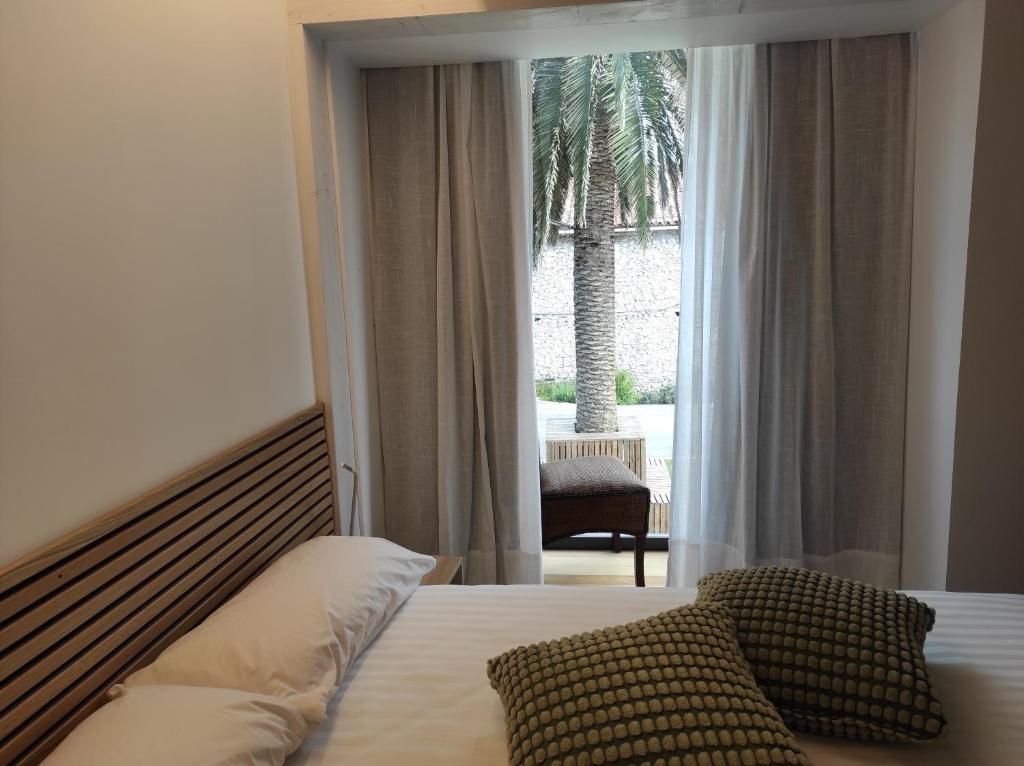 a bedroom with a bed and a window with a palm tree at Casa Playas Costa Quebrada in Santa Cruz de Bezana
