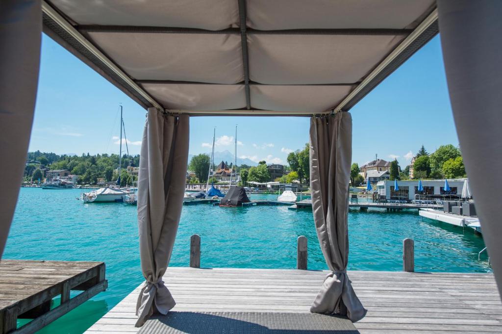 a dock with a tent on the water at Boutique Apartments Velden in Velden am Wörthersee