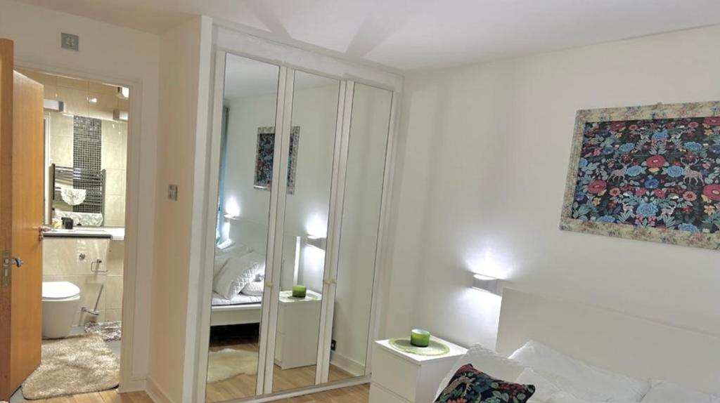 a white bathroom with a toilet and a mirror at Bayswater Apartments in London