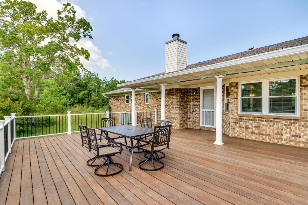 una terraza de madera con mesa y sillas en una casa en Spacious Milton Vacation Rental with Pond On-Site, en Milton