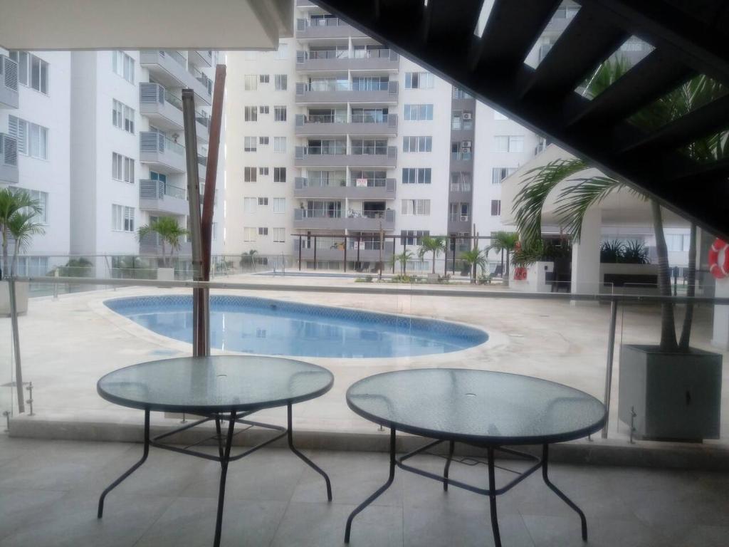 twee tafels voor een zwembad bij Espectacular Apartamento para estrenar en Valledupar in Valledupar