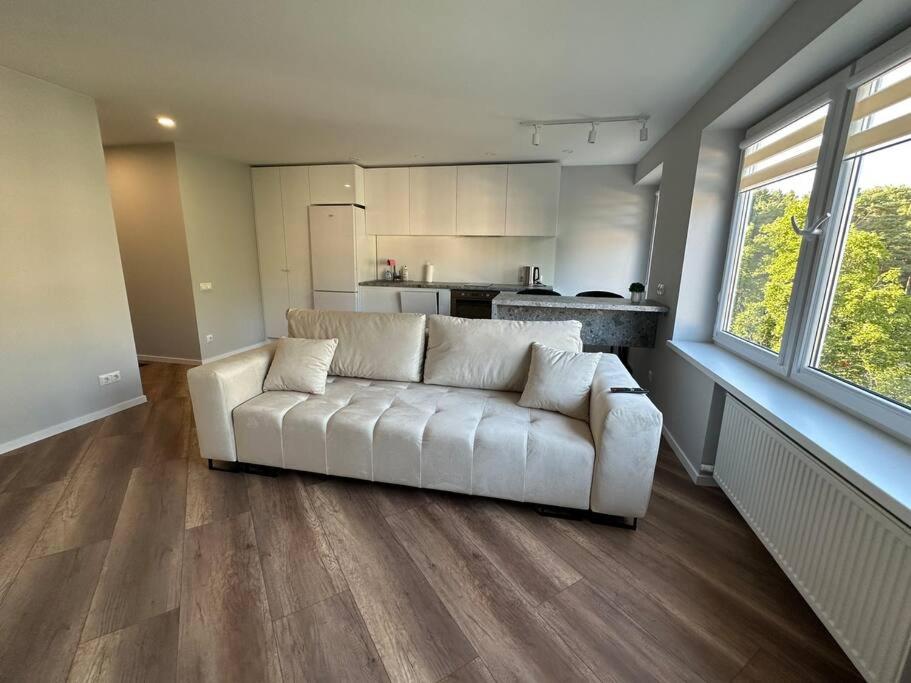 ユールマラにあるSun apartmentの白いソファとキッチンのあるリビングルーム