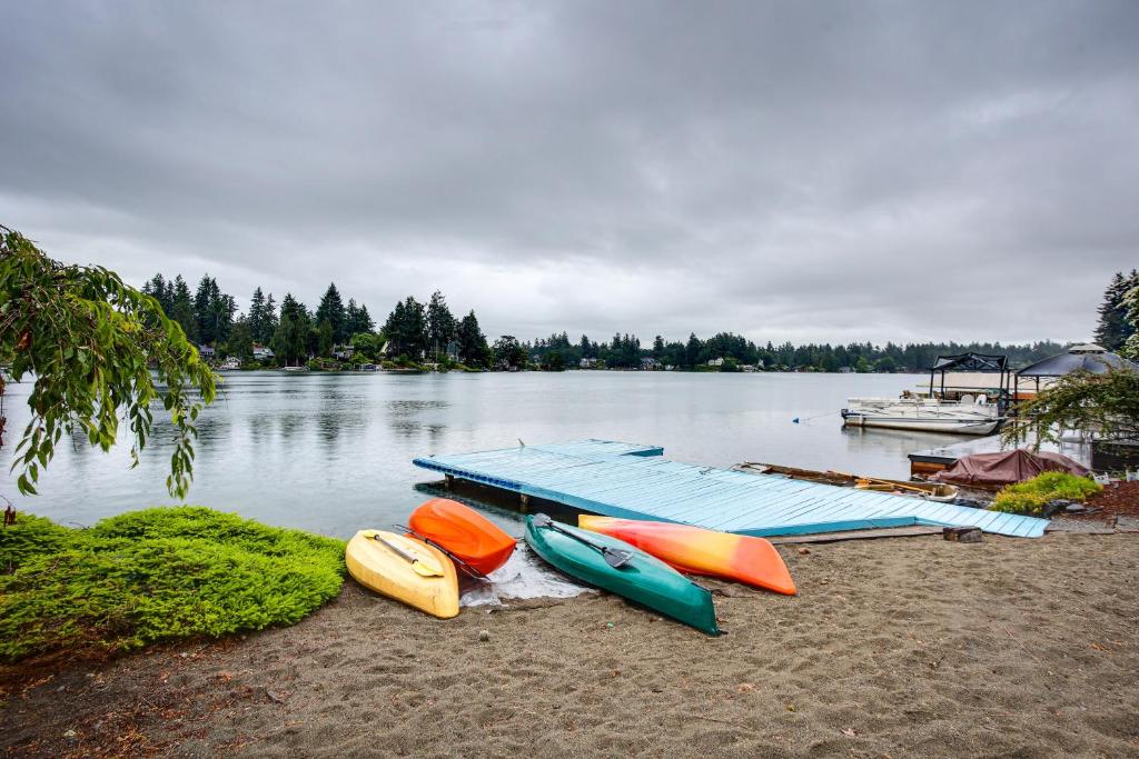 a group of boats sitting on the shore of a lake at Tacoma Home on Steilacoom Lake with Dock! in Tacoma