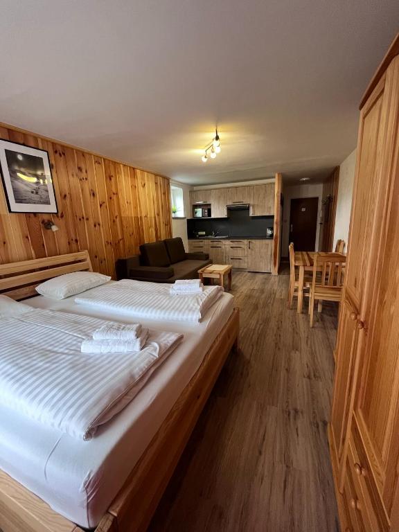 a bedroom with two beds and a living room at Kaprun Mountain Studio with Summer CARD- Central Location in Kaprun