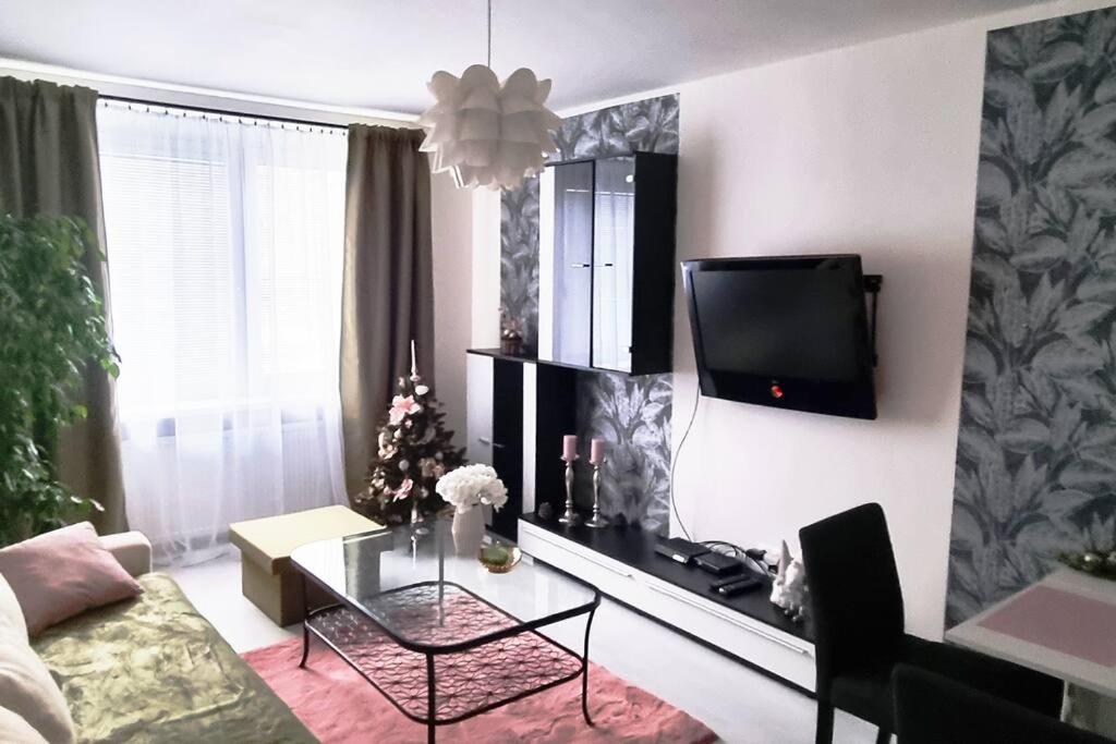 a living room with a table and a tv on the wall at Apartmán v centre mesta Žilina in Žilina