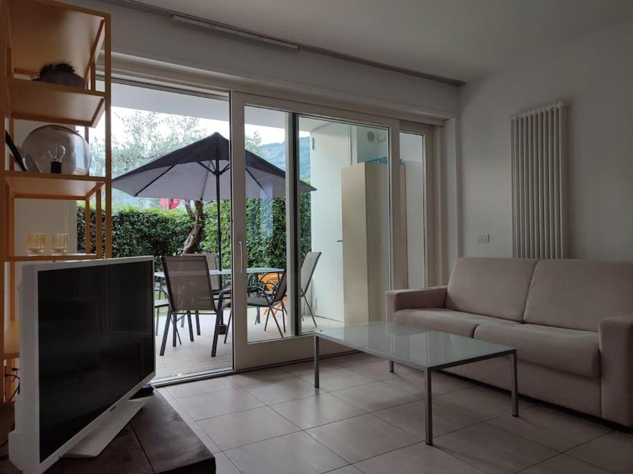 a living room with a couch and a table and an umbrella at L&G APARTAMENT in Nago-Torbole
