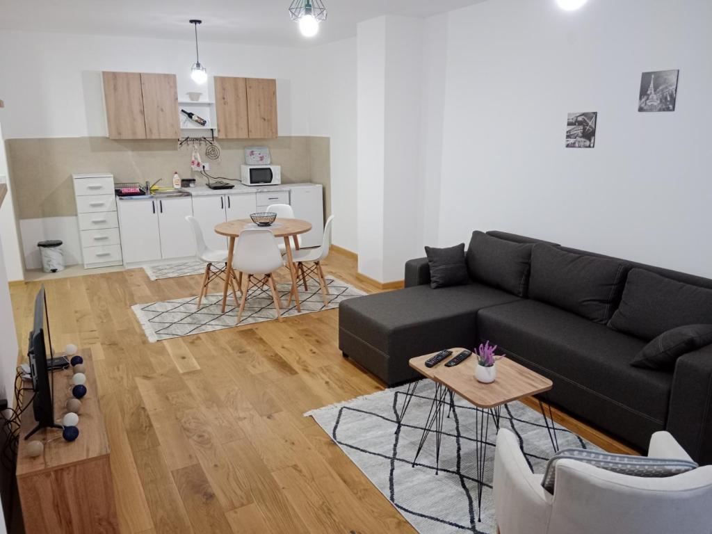 Una sala de estar con un sofá negro y una mesa. en Panorama 17, en Vrnjačka Banja