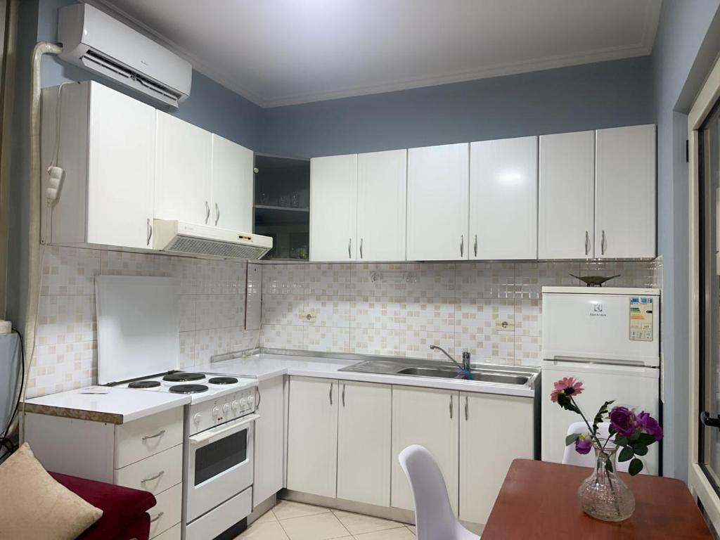 a kitchen with white cabinets and white appliances at Mirela’s Apartment City Center in Tirana