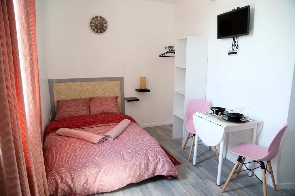 una camera con letto, scrivania e TV di Venus a Saint-Quentin