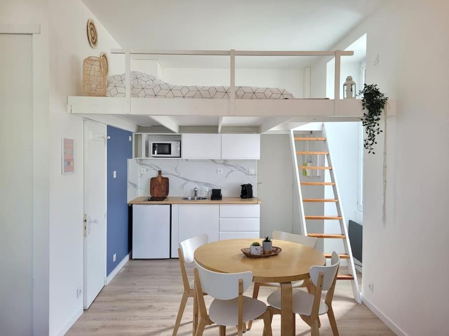 Il comprend une petite cuisine avec une table et un lit en mezzanine. dans l'établissement Cocoon Urbain Nantais, à Nantes