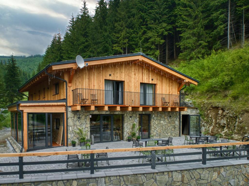 Blockhaus mit Balkon auf einem Dock in der Unterkunft KRÁĽOVOHOĽSKÁ CHATA in Šumiac