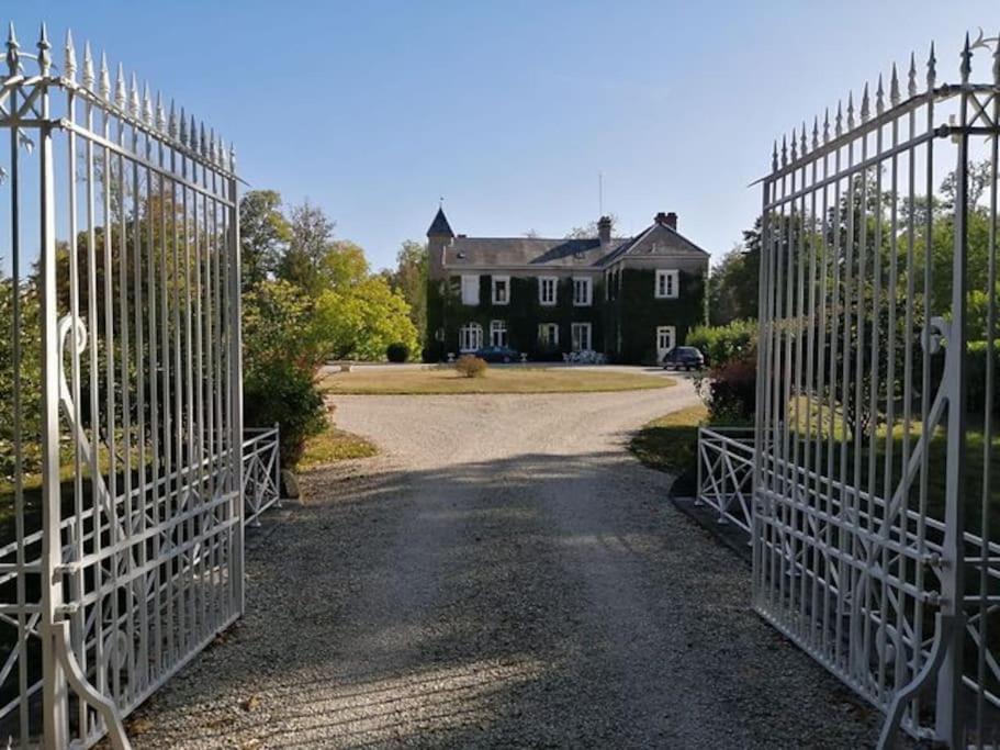ein offenes Tor zu einem Haus mit Auffahrt in der Unterkunft Domaine de Beaucamp in Châtelraould-Saint-Louvent
