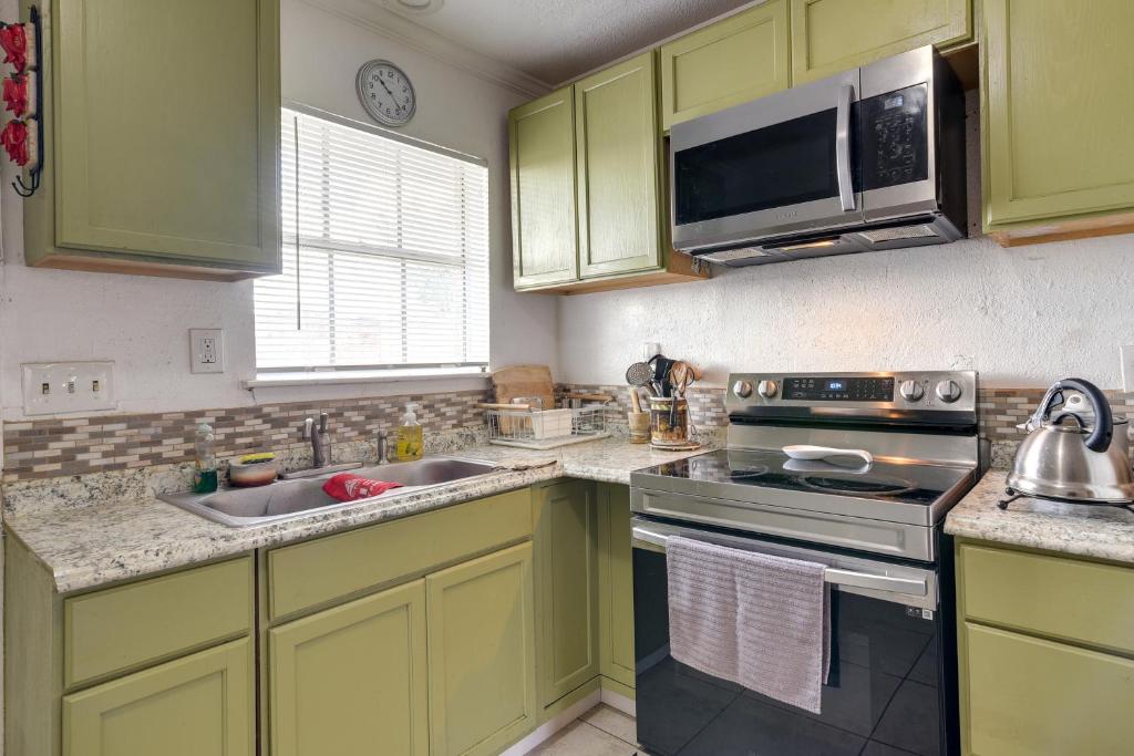 a kitchen with green cabinets and a stove and a microwave at Houston Vacation Rental about 10 Mi to Downtown in Houston
