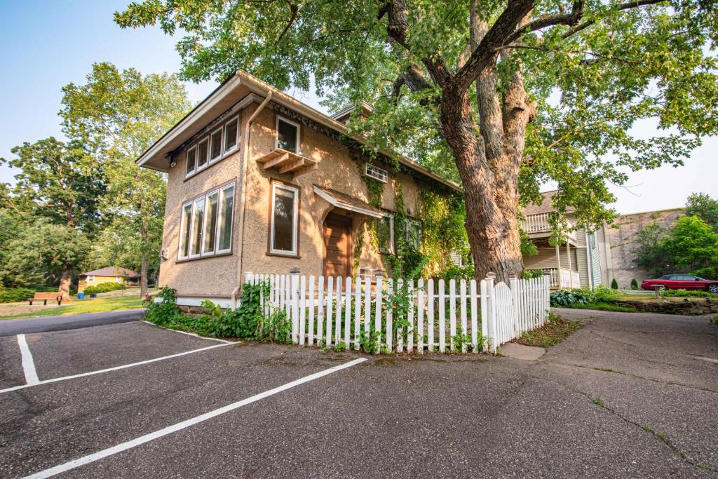 a house with a white fence and a tree at White Rose Inns & Motel in Wisconsin Dells