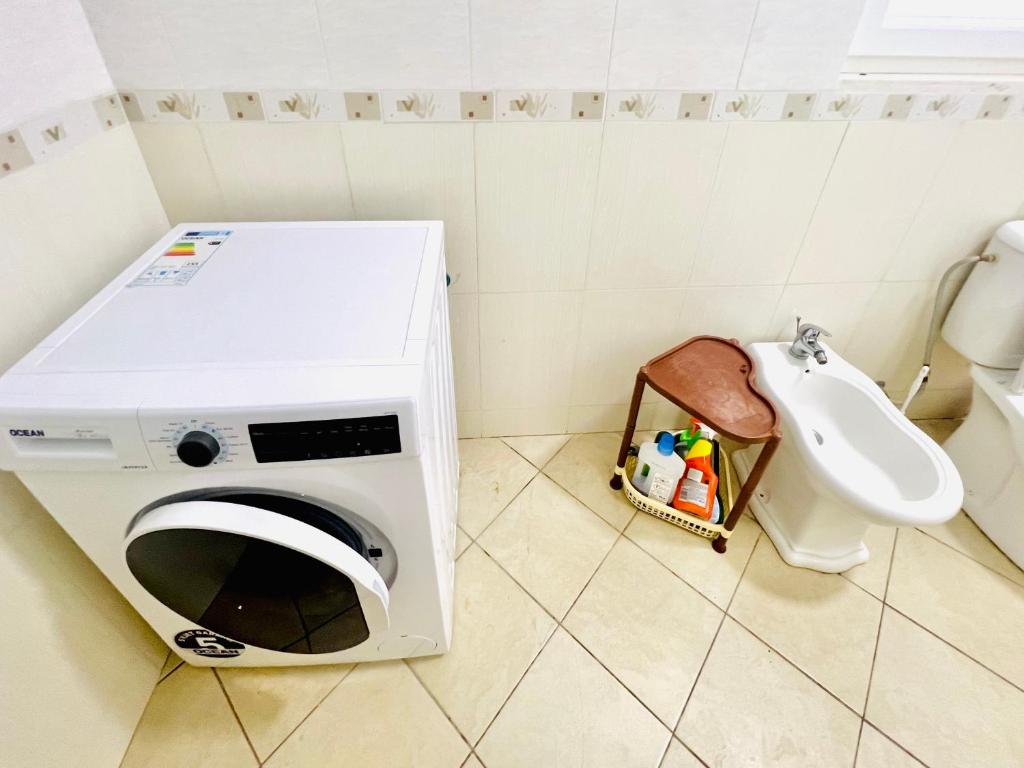 a washing machine in a bathroom next to a toilet at Villa Velipoja in Velipojë