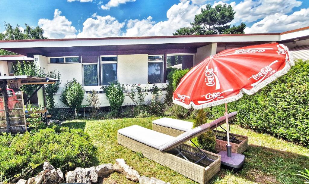 un parapluie et un banc de cocacola devant une maison dans l'établissement Maison des pilotes, à Genève