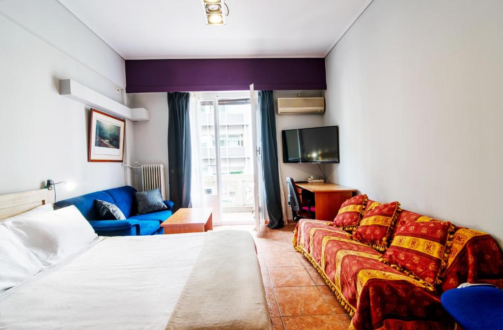 une chambre d'hôtel avec un lit et un canapé dans l'établissement Alpha 1, à Athènes