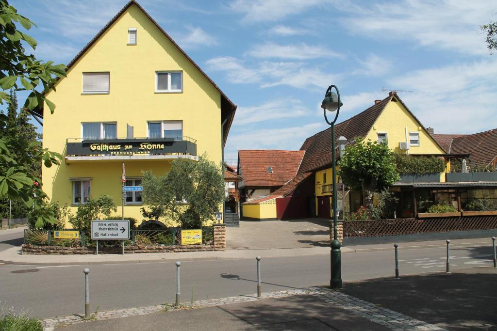 um edifício amarelo no lado de uma rua em Gasthaus Zur Sonne em Friburgo em Brisgóvia