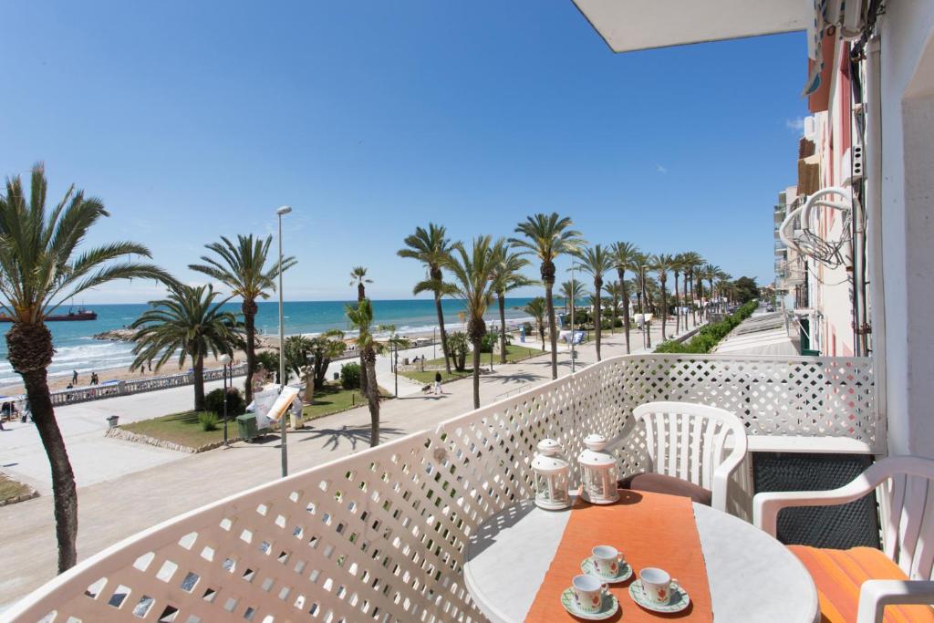 a table and chairs on a balcony with a view of the beach at Liliane Apartment in Sitges