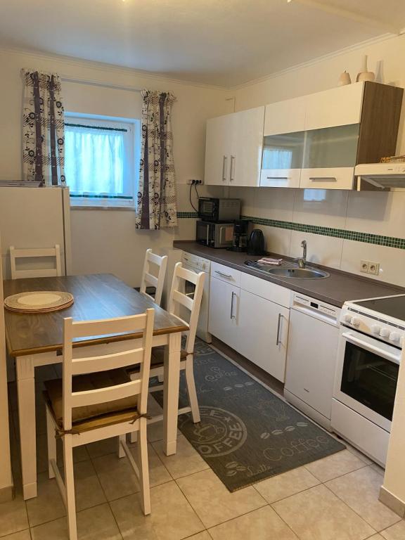a kitchen with a wooden table and a table and chairs at Ostsee Ferienwohnung in Scharbeutz
