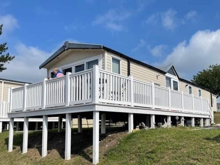 a person standing on a porch of a house at Sea Breeze Cabin in Poole