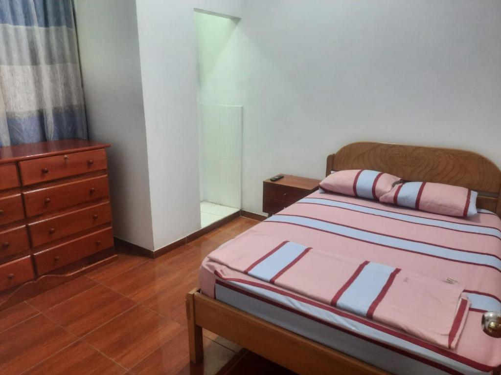 um quarto com uma cama com uma cómoda e uma cama sidx sidx em Casa Grande em Iquitos
