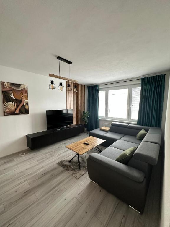 ein Wohnzimmer mit einem Sofa und einem Tisch in der Unterkunft Apartman city center Zvolen in Zvolen