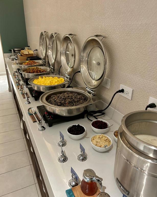 a buffet line with bowls of food on a counter at Fairfield by Marriott San Jose Airport Alajuela in Alajuela City