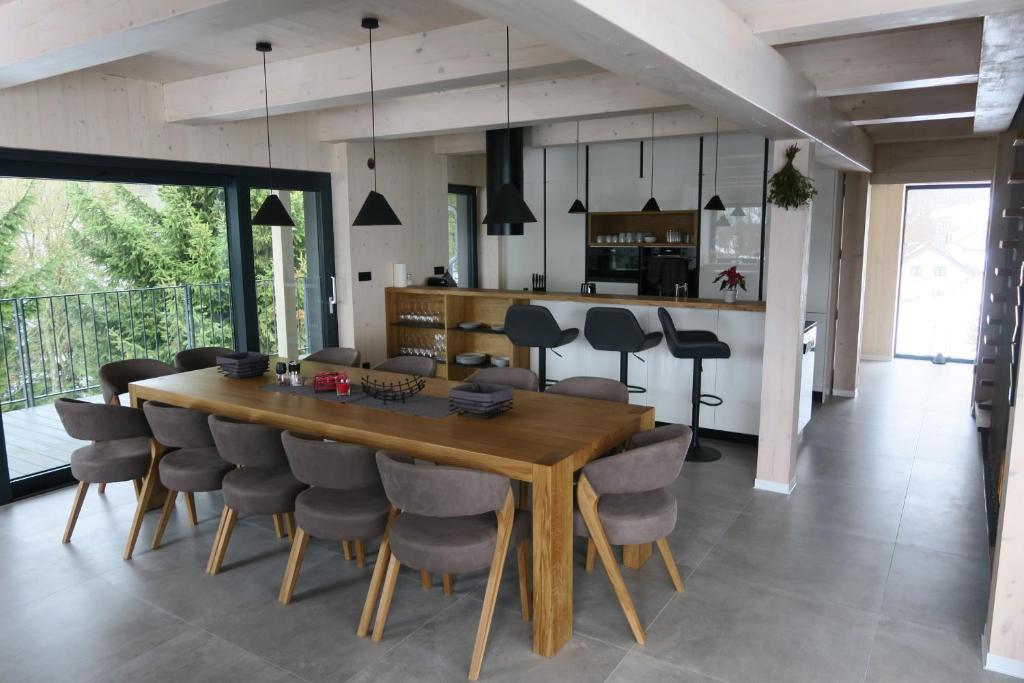 a dining room and kitchen with a wooden table and chairs at Chata Jestřábník in Dolní Morava