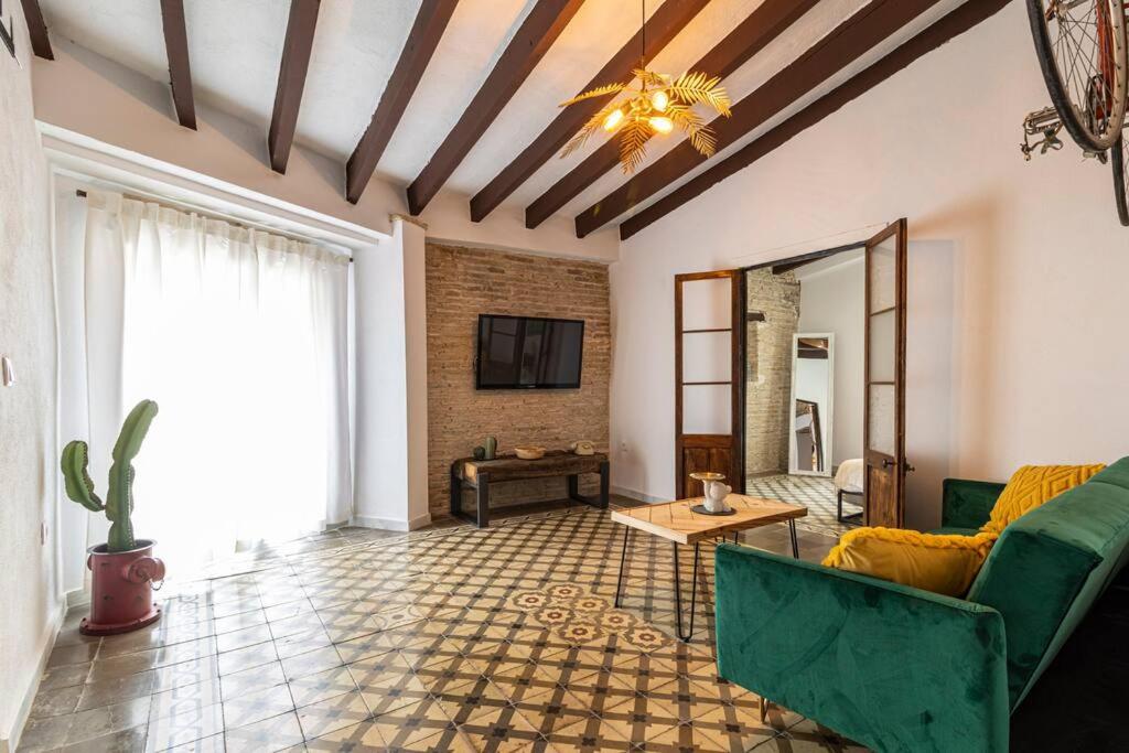 ein Wohnzimmer mit einem Sofa und einem TV in der Unterkunft Kala Ático - Apartamento Centro Jerez in Jerez de la Frontera