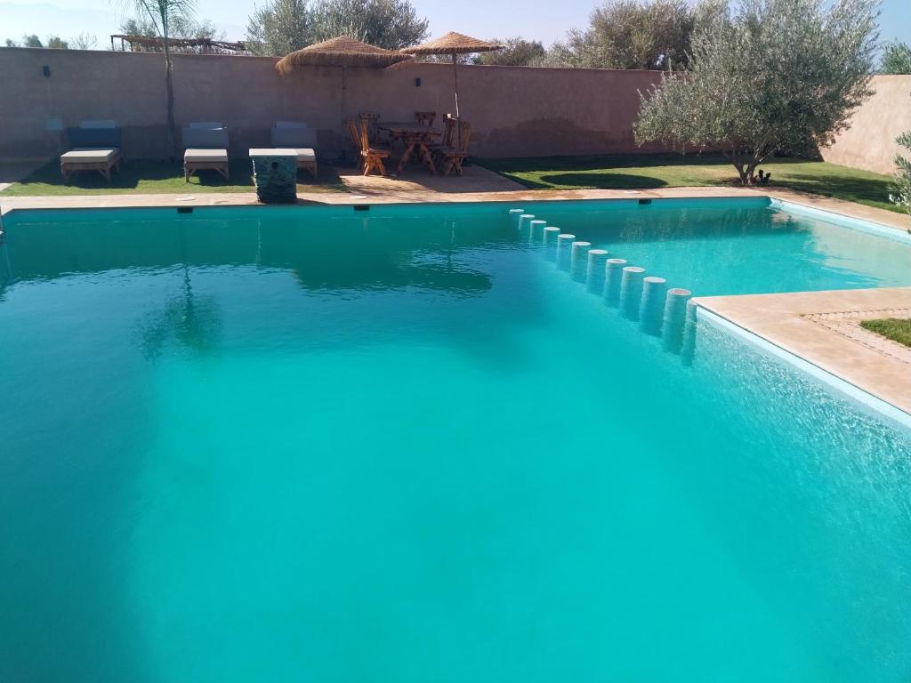 - une piscine d'eau bleue dans la cour dans l'établissement Villa Baraka, à Marrakech