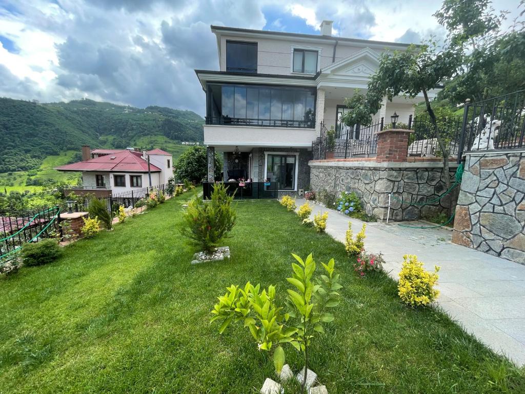 a house on a hill with a green yard at Fuays Villa Premium in Trabzon