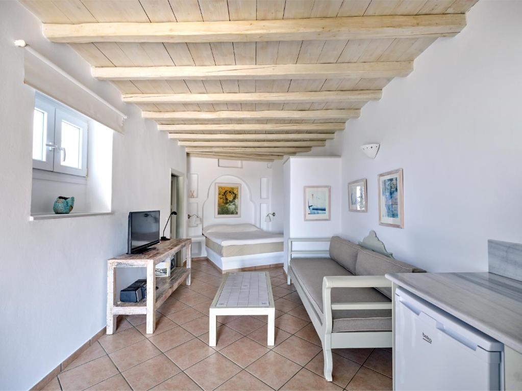 a living room with white walls and a wooden ceiling at Sea View Exclusive Studios - Tinos in Agios Ioannis Tinos