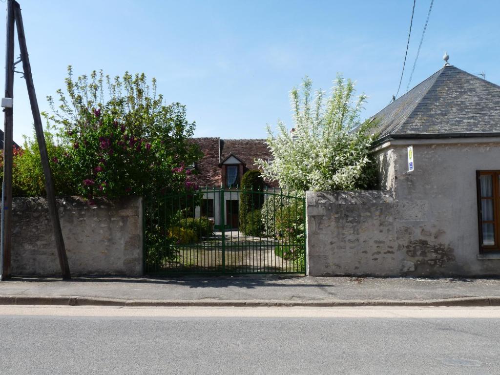 a house with a stone fence and a gate at Ferme Peschard in Séris