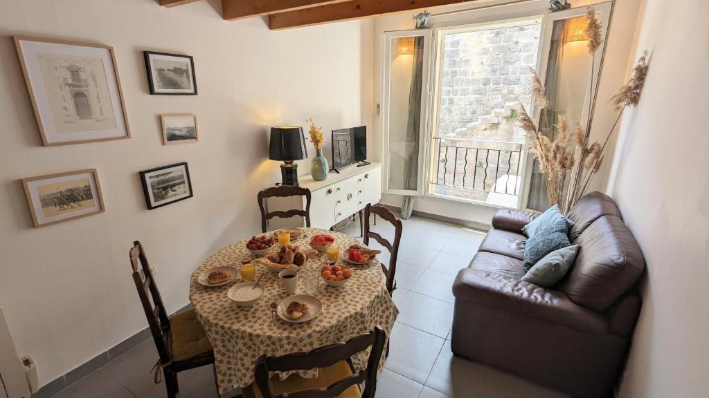 a living room with a table and a couch at Maison de village avec garage in Aigues-Mortes