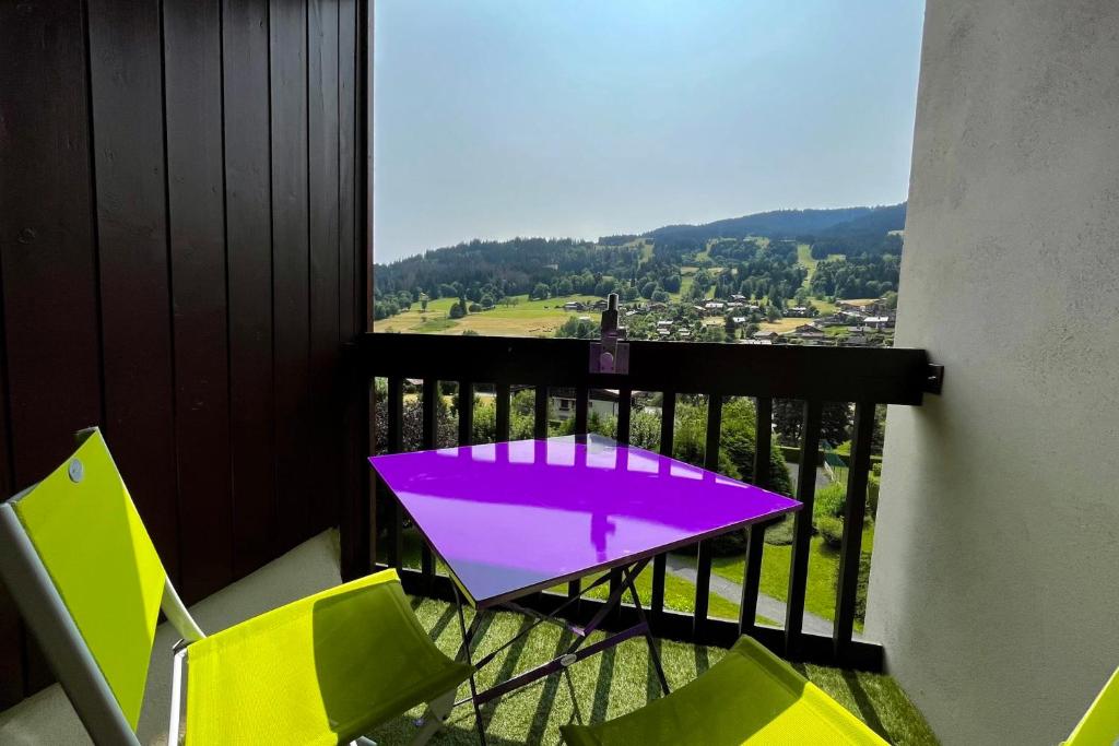 d'une table et de chaises violettes sur un balcon. dans l'établissement Bright studio with view of Aiguille Verte, à Demi-Quartier