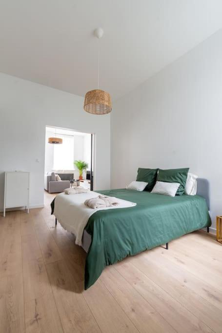 une chambre avec un lit avec une couverture verte dans l'établissement Le Solfé -Magnifique T2, à Lille
