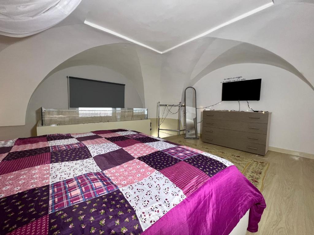 a bedroom with a bed and a flat screen tv at Living Dalia in Carovigno