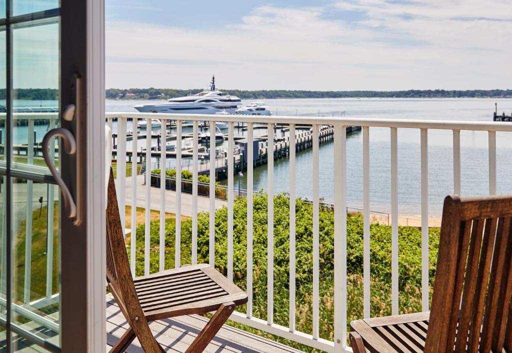 a balcony with a chair and a view of a marina at The Harbor Front Inn in Greenport