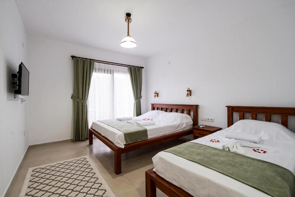 a bedroom with two beds and a window at Nirvana Boutique Hotel in Datca