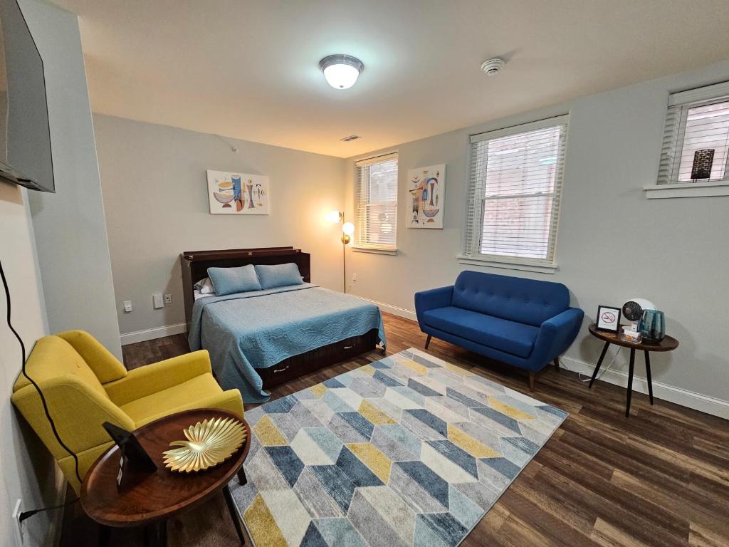 a bedroom with a bed and a couch and a table at Cozy Studio at the Historic Inman in Champaign